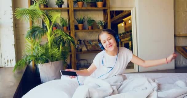 Πλάνα Ενός 10Χρονου Κοριτσιού Κάθεται Ένα Κρεβάτι Ακουστικά Και Ακούγοντας — Αρχείο Βίντεο