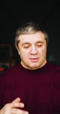 A middle-aged man covering his face with his hand - a sign of disapproval and shame. Facepalm. Close-up vertical portrait. 4k footage.