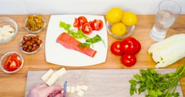 Top view - male hands cut the cheese into pieces. Cooking. keto diet and healthy low carb diet for weight control. Vertical slow motion 4k. Slow motion 4k video.