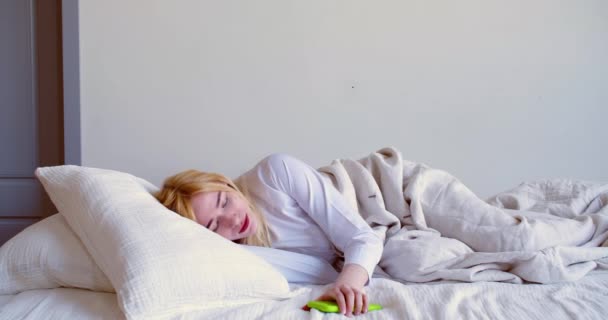 20歳の女性が目を覚ますと スマートフォンでメッセージをチェックし 眠りに落ちる ソーシャルメディア中毒の概念 スローモーション4K映像 — ストック動画
