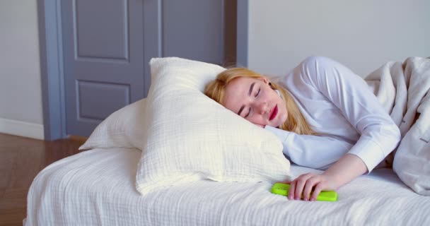 ソーシャルメディア中毒の概念 20歳の女性が目を覚ますと スマートフォンでメッセージを確認し 眠りに落ちるのクローズアップビデオ スローモーション4K映像 — ストック動画