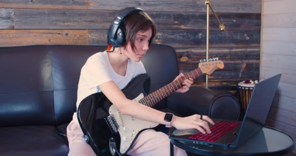 온라인 강의중어린 기타리스트 기타를 가지고 소녀는 집에서 노트북 동영상 — 비디오