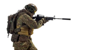 Professional special forces soldier during a special operation. Mercenary soldier with an automatic rifle in his hand aiming in enemy. Photo isolated on white.