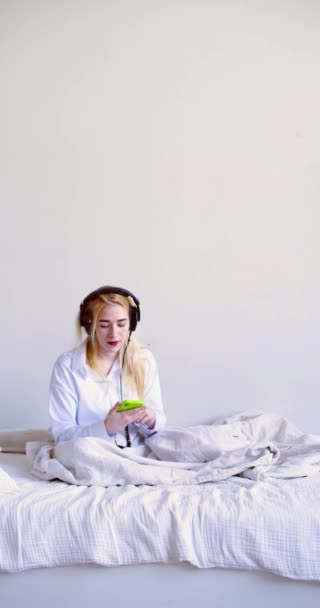 Bir Kadın Uyandı Yatakta Otururken Kulaklıkla Müzik Dinledi Günlük Yaşam — Stok video