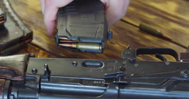 Kalashnikovアサルトライフルに雑誌を添付男性の手の近くにドリーショット 戦闘の準備だ スローモーション4K映像 — ストック動画