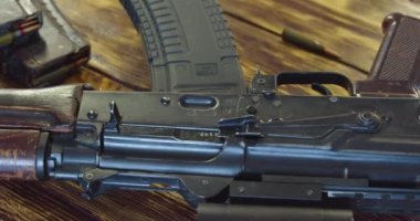 Kalaşnikof saldırı tüfeğinin Dolly 'si. Kamera silah boyunca hareket ediyor. Savaş için hazırlık. Yavaş çekim. 4k yakın çekim videosu.