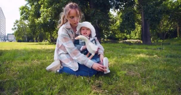 Uma Jovem Mãe Senta Grama Parque Com Sua Filhinha Ela — Vídeo de Stock