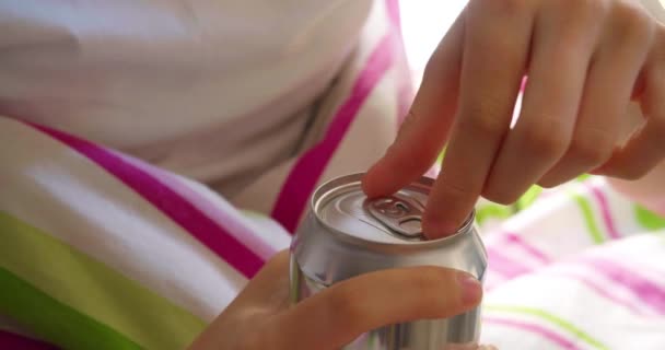 一名少女坐在床上 打开一罐能量饮料 视频强调了未成年人饮用高咖啡因和高糖饮料的危险 手部特写 — 图库视频影像