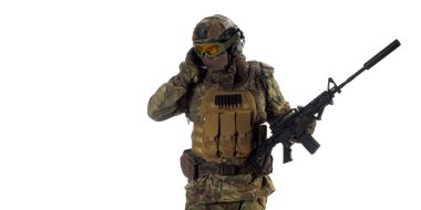 Profesyonel bir paralı asker yan yana bakarken telsizden destek istiyor. Beyaz arkaplanda fotoğraf.