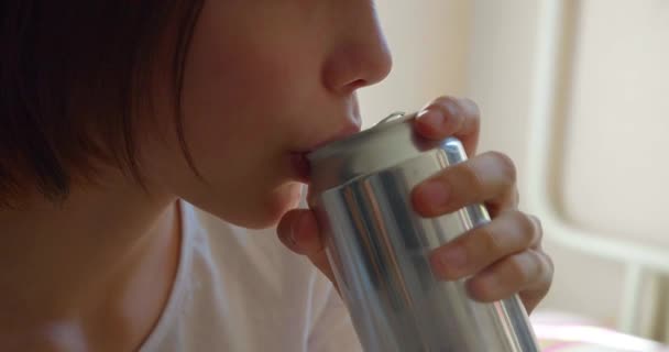 缶からエネルギーを飲んでいる10代の少女を撮影したストック映像です ビデオでは これらのタイプの飲み物に含まれる化学成分の有害な影響と中毒性を強調しています — ストック動画