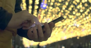 İyi geceler, akıllı telefonlu erkek ellerinin yakın çekimi. İletişim ve büyük bir şehirde çalışmak. Modern bir şehirde hayatın ritmi ve insanların sosyal ağlara ve internete olan bağımlılığı.