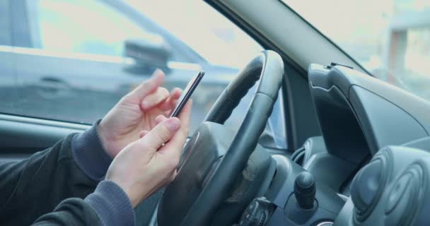 男性与智能手机司机手牵手 用他的智能手机浏览网站 社交媒体和来自汽车舒适性的新闻 — 图库视频影像