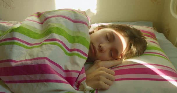 Genç Bir Kız Yüzünde Güneşin Sıcaklığıyla Uyanıyor Kıvrılıp Yorganın Altına — Stok video