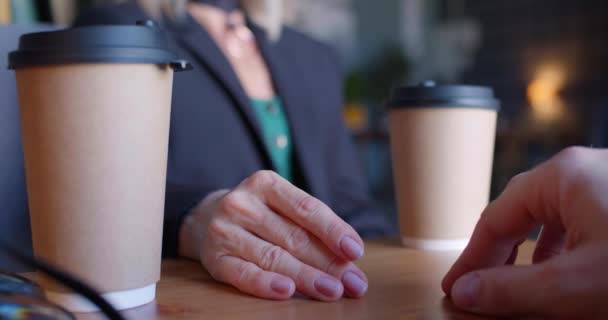 男は慎重に女性の手に触れ 戦いの後に和解し カフェで彼女の指をストロークします クローズアップカップルの手 優しさの瞬間 4K映像 — ストック動画