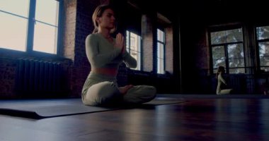 Meditasyon yoga pratiği. Karanlık bir odada genç bir kadın zihinsel dengeyi sağlamak için emekli oldu. Akıl sağlığı ve dijital detoks. Yavaş çekim 4k görüntü.