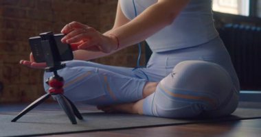 Genç bir kadının videosu akıllı telefondan yoga rehberini seçiyor ve meditasyon yapmaya başlıyor. Dünyanın her yerinde deneyimli akıl hocalarının rehberliğinde çevrimiçi eğitim..