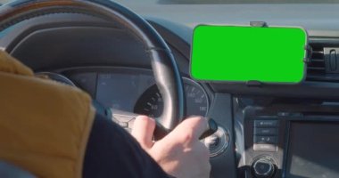 Akıllı telefonunda GPS navigatörü olan herhangi bir yere. Sürücü navigasyon için bir uygulama kullanarak seyahat ederken bir araba kullanıyor. 60 fps kırpılmış 4K görüntü.