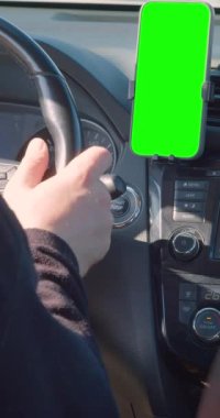 Akıllı telefonunda GPS navigatörü olan herhangi bir yere. Sürücü navigasyon için bir uygulama kullanarak seyahat ederken bir araba kullanıyor. Dikey 4k görüntü.