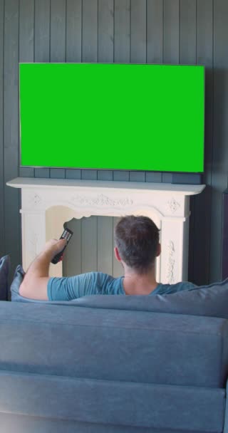 Mann Sitzt Und Wechselt Die Kanäle Auf Dem Grünen Bildschirm — Stockvideo