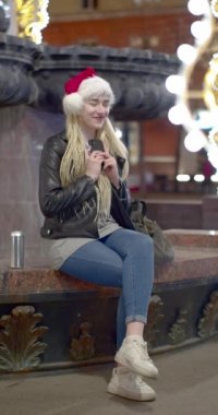 Noel Baba şapkalı genç beyaz kadın Noel arifesinde sevdiği birinden mesajlar aldı. O mutlu. Yavaş çekim 4k görüntü.