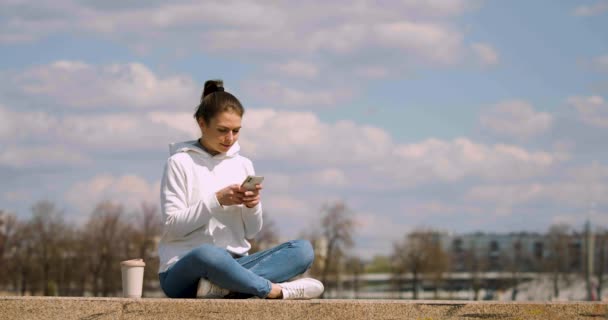 Metraje Una Mujer Meditando Terraplén Ella Baja Smartphone Comienza Meditar — Vídeo de stock