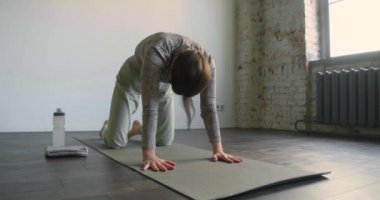 Pilates sağlık için bir egzersiz. Sırtını esneten genç bir kadının yavaş çekim 4K görüntüleri..