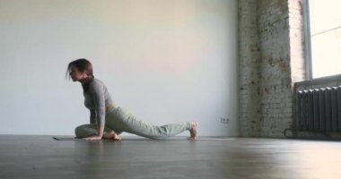 Güvercin pozu - yoga ve meditasyon pratiği. Genç bir kadın yoga yaparak huzurunu geri kazanmak için kendini gözden uzak tuttu. Yavaş çekim 4k görüntü.