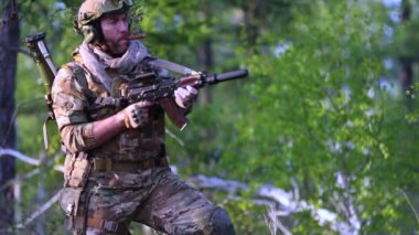 Vurulan asker. Modern savaş. Ormanda bir asker makineli tüfekle ateş ediyor. FHD yavaş çekim 25 fps video.