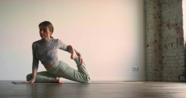 Yoga ve meditasyonu bir yaşam tarzı olarak uygulamak. Karanlık bir odada genç bir kadın yoga yaparak huzurunu geri kazanmak için kendini gözden uzak tuttu. Yavaş çekim 4k görüntü.