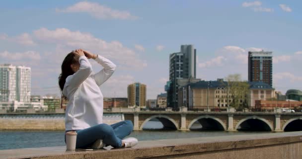 Молодая Женщина Сидит Поднятыми Руками Перед Городским Пейзажем Дыхание Свободы — стоковое видео