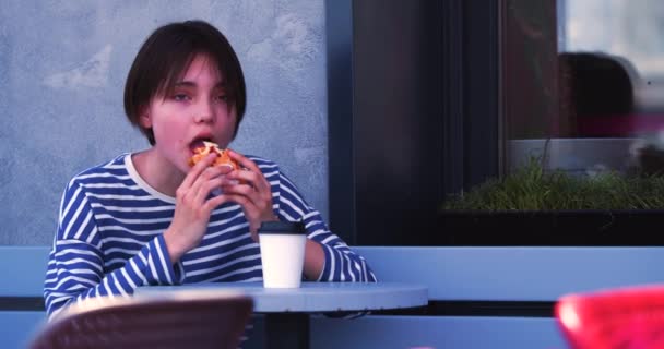 快餐上瘾 在人行道咖啡店吃芝士汉堡的少女 慢动作4K镜头 — 图库视频影像