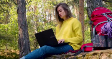 Online eğitim ve iş. Genç bir kadın, büyük şehrin koşuşturması ve koşuşturması sayesinde dizüstü bilgisayarla çalışıyor. Günümüzde dijital dünyada serbest çalışma ve akıl sağlığı kavramı.