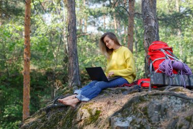 Online eğitim ve iş. Genç bir kadın, büyük şehrin koşuşturması ve koşuşturması sayesinde dizüstü bilgisayarla çalışıyor. Günümüzde dijital dünyada serbest çalışma ve akıl sağlığı kavramı.