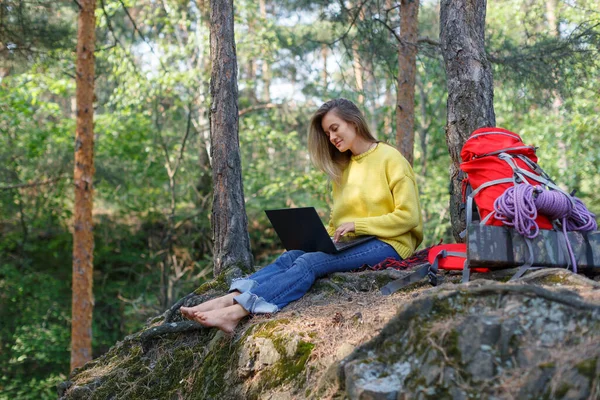 Online education and work. A young woman works through a laptop remotely from the hustle and bustle of the big city. The concept of freelancing and mental health in todays digital world.