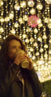 Genç bayan Noel arifesinde sıcak içkiden hoşlanır. Yavaş çekimde dikey 4k 'lık görüntüyü kapat.