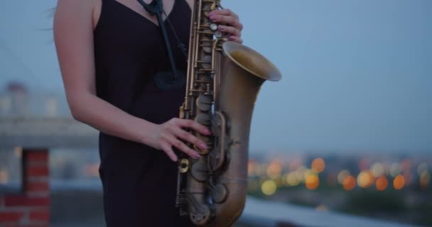 Vídeo Recortado Una Mujer Toca Saxofón Mientras Está Pie Techo — Vídeo de stock