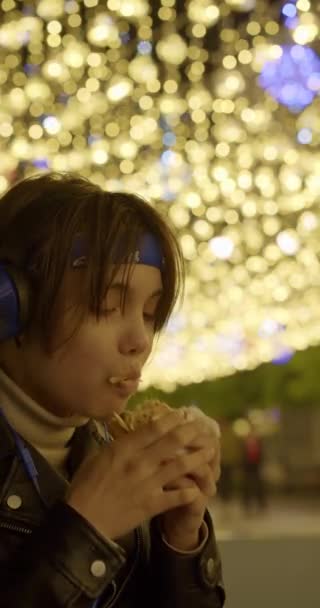 Девочка Подросток Наушниках Ест Гамбургер Пристрастие Молодежи Нездоровой Пище Fast — стоковое видео