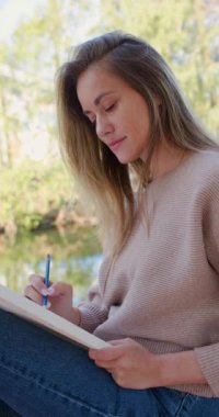 Açık havada çizim yapan kadın ressamın yakın çekim videosu. Çizim yoluyla psikolojik rahatlama. Yavaş çekim dikey 4k video.