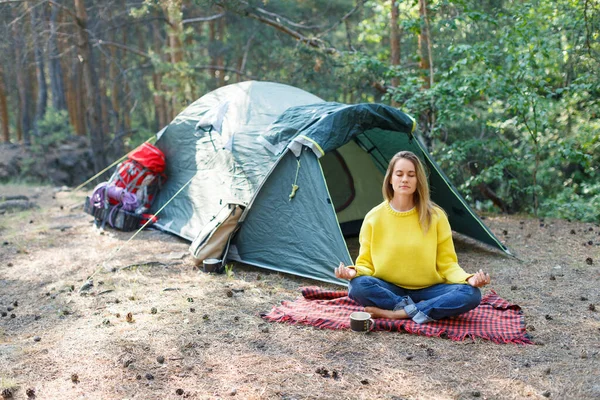 Sabah ormanıyla nefes al ve zihnini meditasyonla özgür bırak. Genç bir kadın sabah çam ormanında meditasyon yapıyor. Düşüncelerinle ve doğanla yalnızlık.