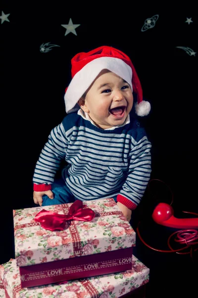 Милый Маленький Мальчик Открывающий Рождественские Подарки Возле Красного Винтажного Телефона — стоковое фото