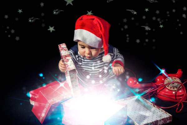 Милый Маленький Мальчик Открывающий Рождественские Подарки Возле Красного Винтажного Телефона — стоковое фото