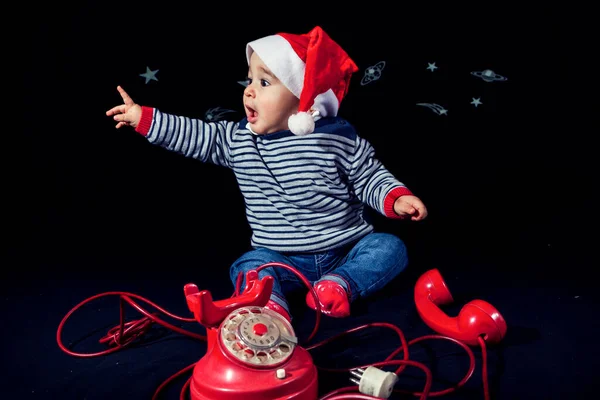 Портрет Улыбающегося Мальчика Рождественской Шляпе Рядом Красным Винтажным Телефоном Черном — стоковое фото