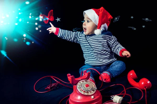 Портрет Улыбающегося Мальчика Рождественской Шляпе Рядом Красным Винтажным Телефоном Черном — стоковое фото