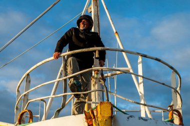 Orta yaşlı bir adam, gece yarısı güneşinde İzlanda sahilinde mahsur kalmış bir teknede kaptan rolü oynuyor.