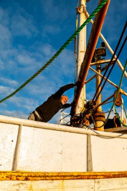 Orta yaşlı bir adam, gece yarısı güneşinde İzlanda sahilinde mahsur kalmış bir teknede kaptan rolü oynuyor.