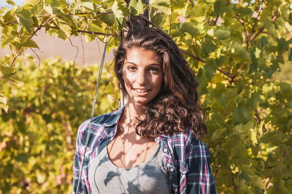 魅力的な女性ワインメーカーが木にもたれてブドウ畑にポーズをとって — ストック写真