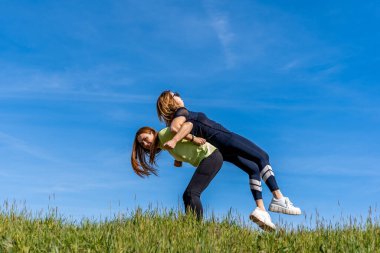 Birkaç güzel atletik kadın dışarıda jimnastik yapıyor. Sağlık konsepti.