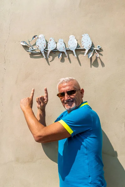 Mężczyzna Średnim Wieku Zabawy Wskazując Znak Żelaza Kształcie Ptaków — Zdjęcie stockowe