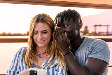 Nişanlı çok ırklı bir çiftin portresi. Yaz tatilinde bir nehir gezisi gemisinde eğleniyorlar.