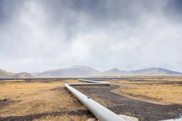 geothermal energy pipelines running along the desert hills of iceland - sustainable and clean energy concept